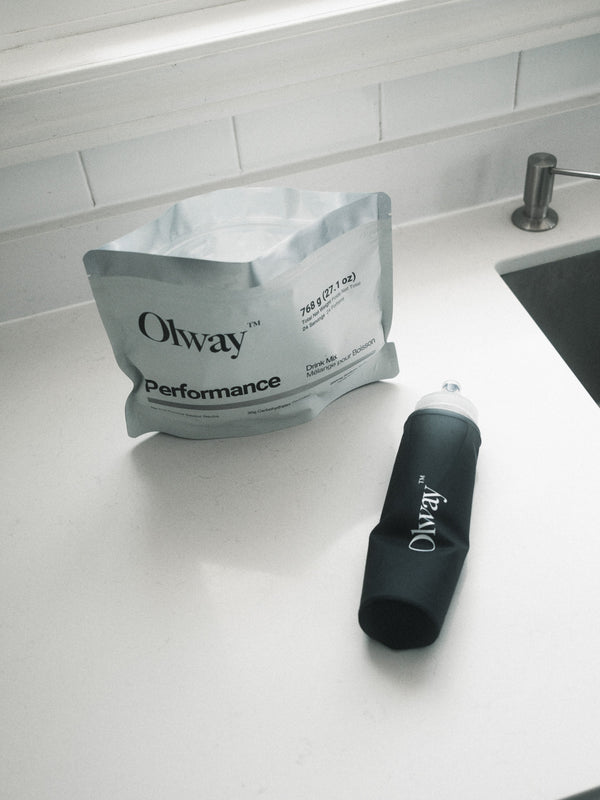 Performance Drink Mix pouch beside a rolled Olway Hydration Flask 500ml on a kitchen counter