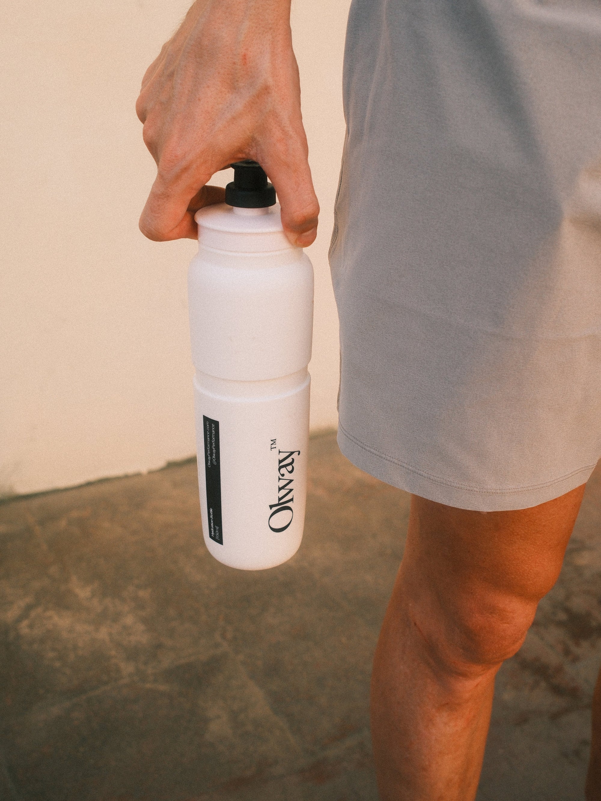 A runner carrying the Olway Hydration Bottle 950ml by its nozzle