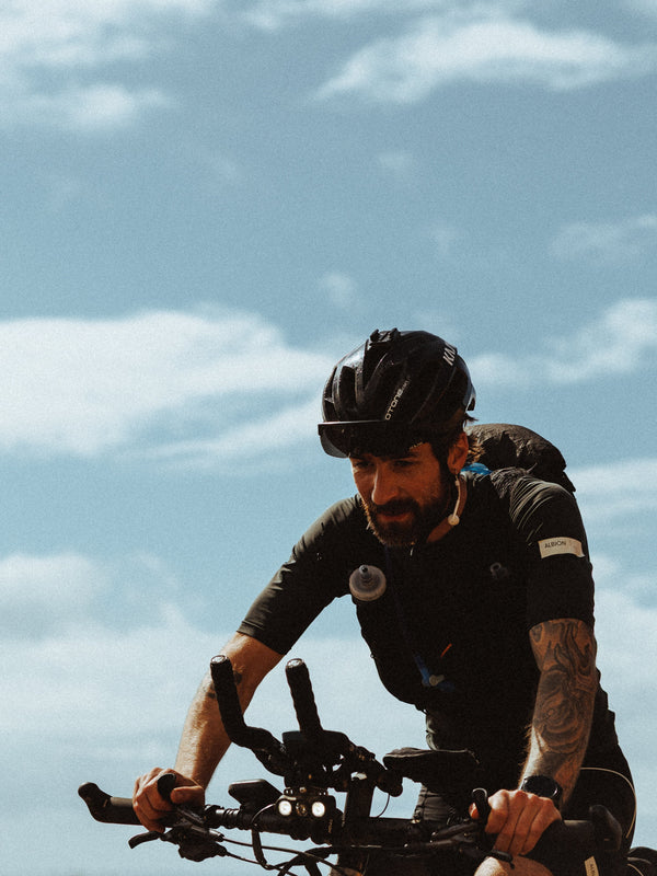 A cyclist riding gravel with an Olway Hydration Flask 500ml in a jersey pocket