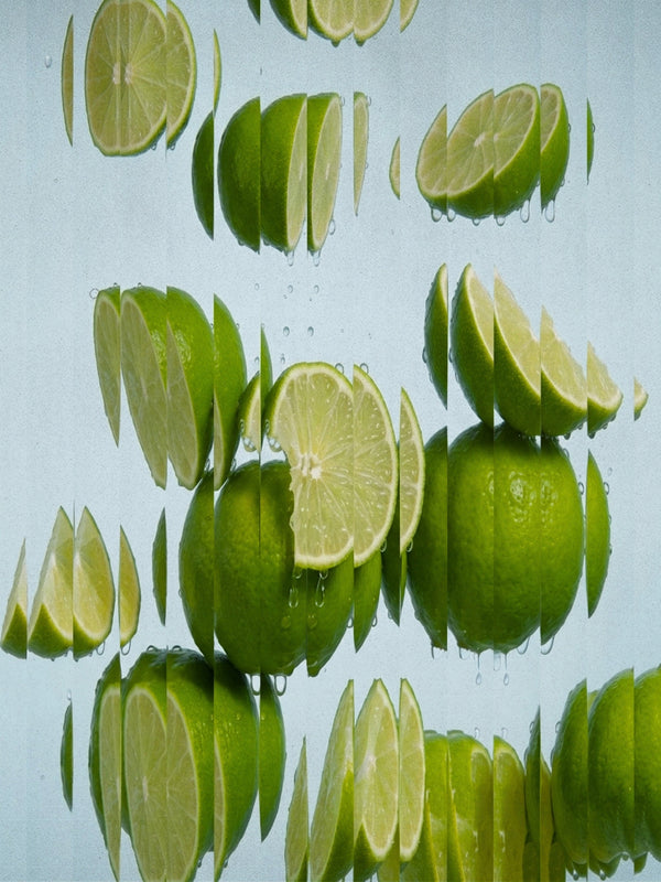 Fresh green limes, both whole and sliced, floating and reflected in clear water against a pale blue background. Lime Salt